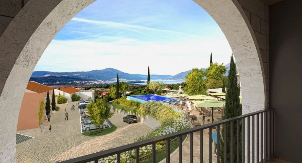 View through an arched Royal Town Kotor balcony toward the planned pool and landscape
